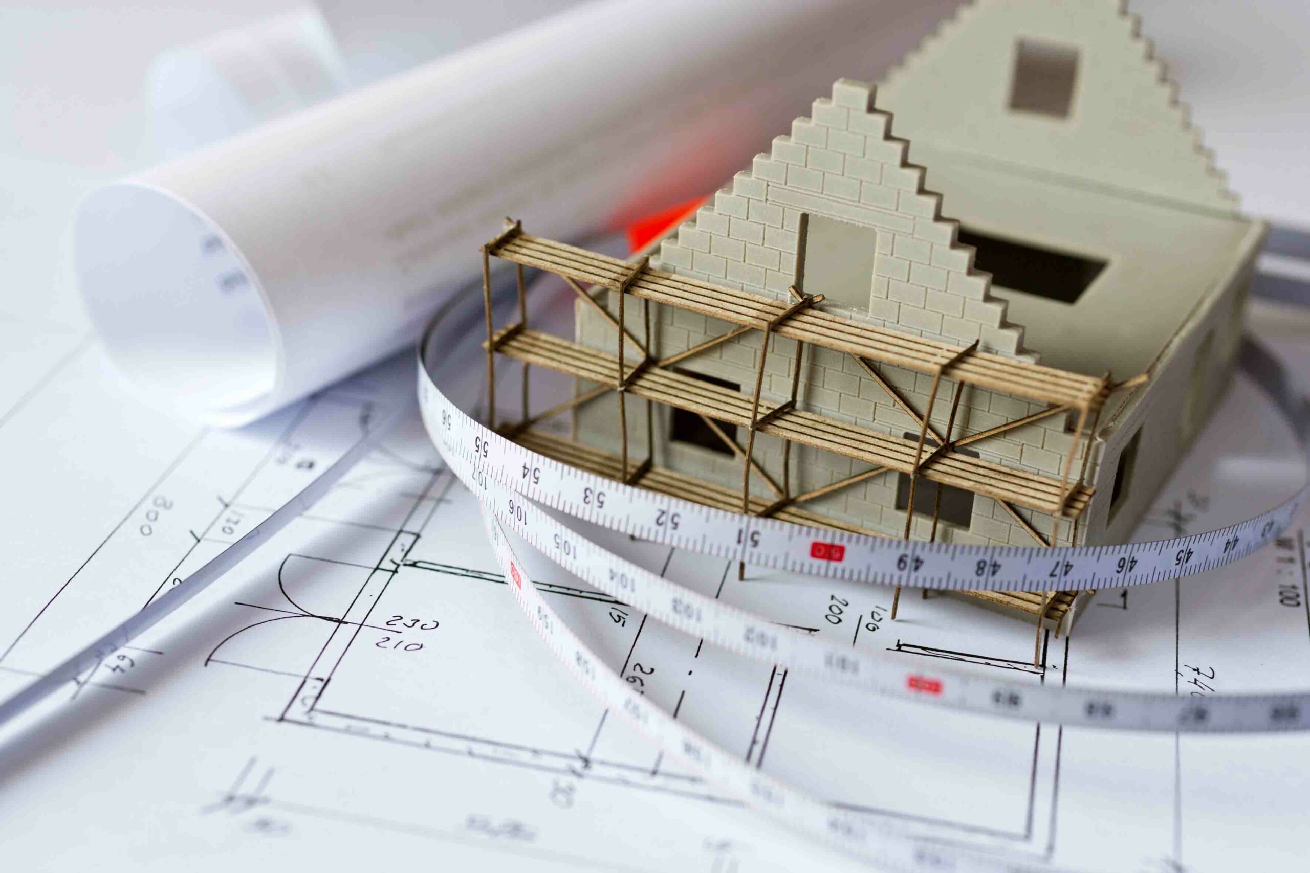 New,Model,House,With,Scaffolding,On,Architecture,Blueprint,Plan,At